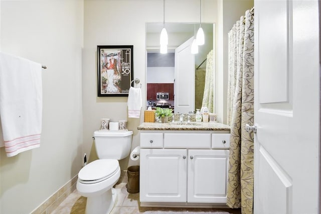 bathroom with toilet, vanity, and tile patterned floors