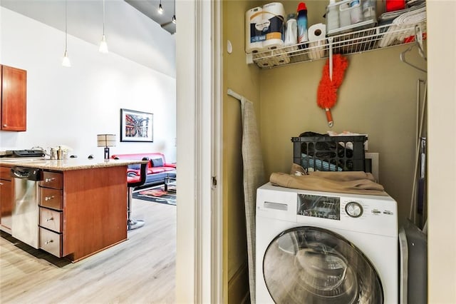 laundry area with washer / dryer and light wood-type flooring