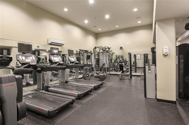1201 Canal St Unit 271, New Orleans, LA 70112 - exercise room with an AC wall unit, a high ceiling, and recessed lighting