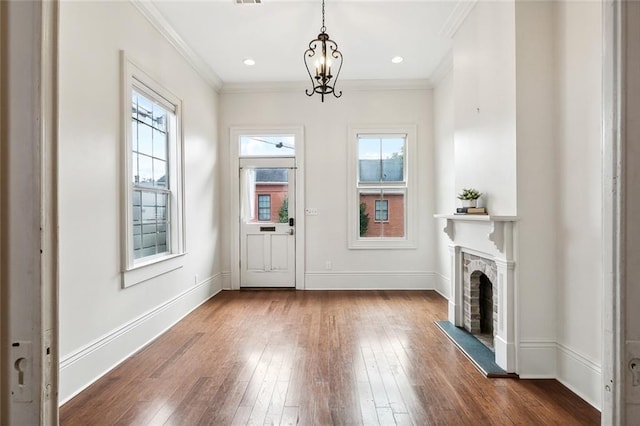 1805 Governor Nicholls St, New Orleans, LA 70116 - entrance foyer with dark wood-type flooring, a fireplace with raised hearth, and crown molding