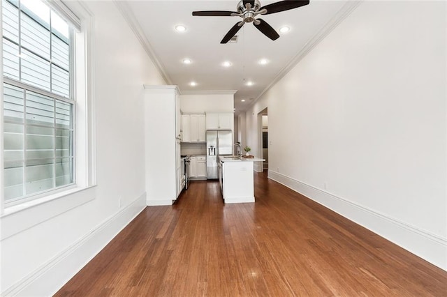 unfurnished living room with sink, ceiling fan, dark hardwood / wood-style flooring, and crown molding