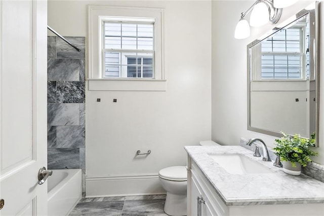 full bathroom with vanity, tiled shower / bath combo, and toilet