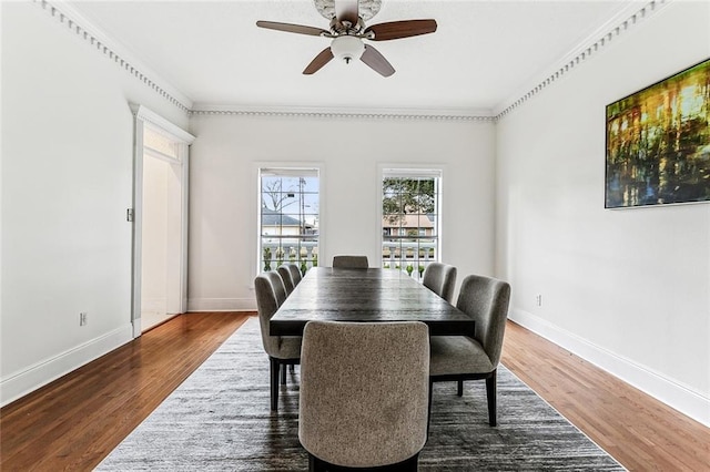 dining space featuring dark hardwood / wood-style flooring, ceiling fan, and crown molding