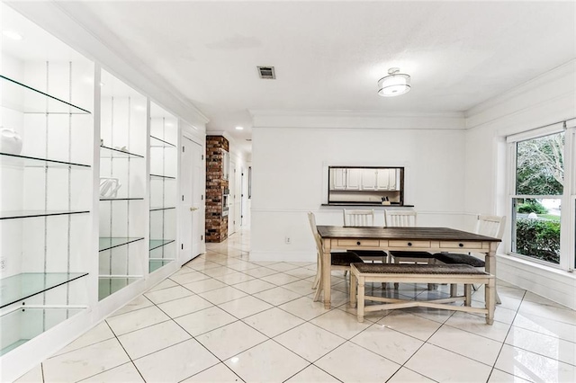 unfurnished dining area with light tile patterned flooring and ornamental molding