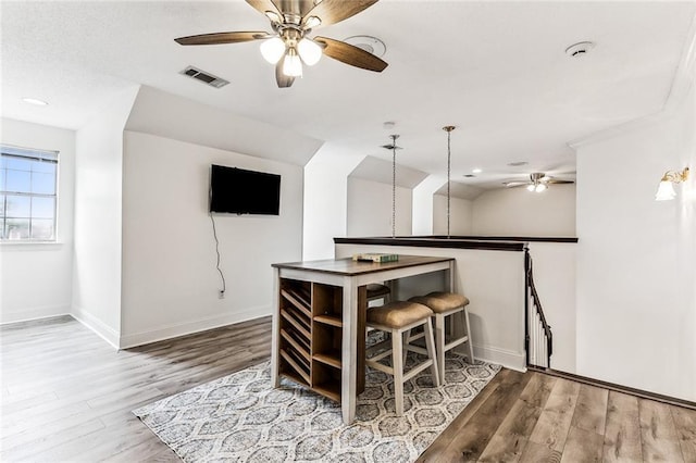 bar featuring decorative light fixtures and hardwood / wood-style floors