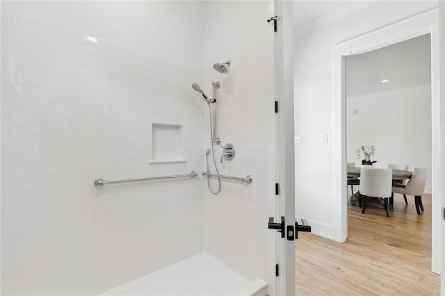 bathroom featuring hardwood / wood-style floors and tiled shower