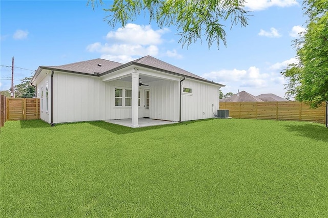 rear view of house with central AC unit, ceiling fan, a yard, and a patio area