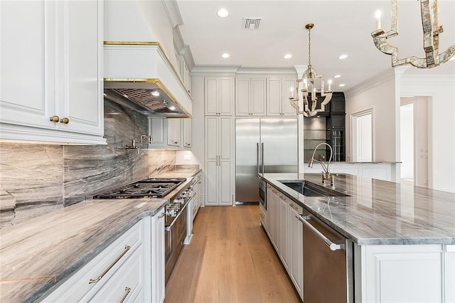 kitchen featuring white cabinetry, hanging light fixtures, a spacious island, and premium appliances