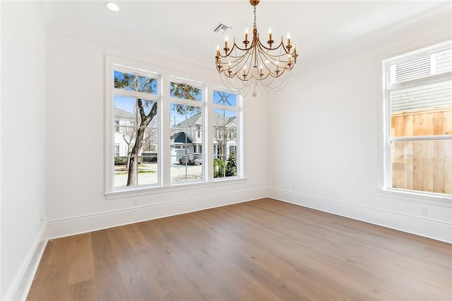 unfurnished dining area featuring ornamental molding, a notable chandelier, and hardwood / wood-style flooring