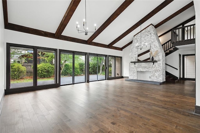 unfurnished living room featuring high vaulted ceiling, an inviting chandelier, a fireplace, beamed ceiling, and wood-type flooring