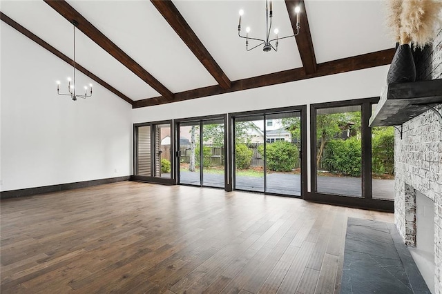 unfurnished living room featuring hardwood / wood-style flooring, a fireplace, high vaulted ceiling, and a chandelier