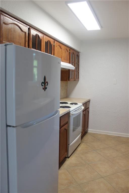 kitchen with white appliances and light tile patterned flooring