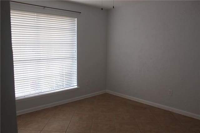 unfurnished room with dark tile patterned floors