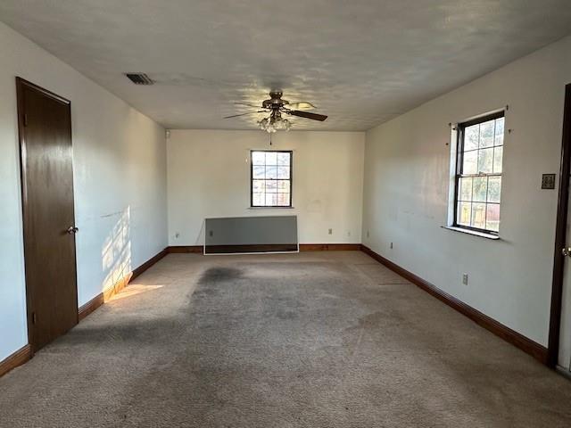 carpeted empty room featuring a textured ceiling and ceiling fan