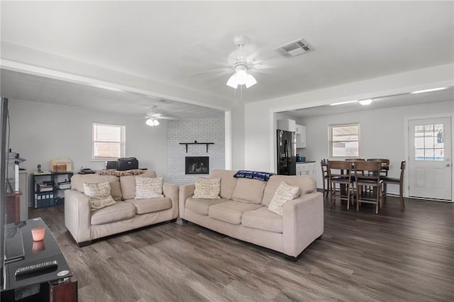 living room featuring a fireplace, dark hardwood / wood-style floors, and ceiling fan