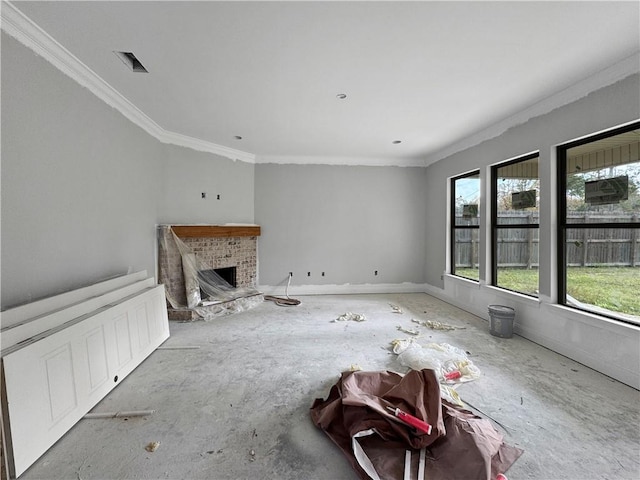 unfurnished living room with ornamental molding and a brick fireplace