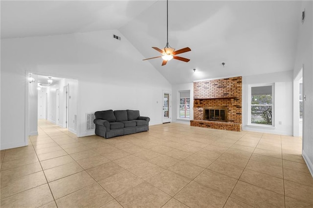 unfurnished living room with ceiling fan, light tile patterned floors, high vaulted ceiling, and a brick fireplace