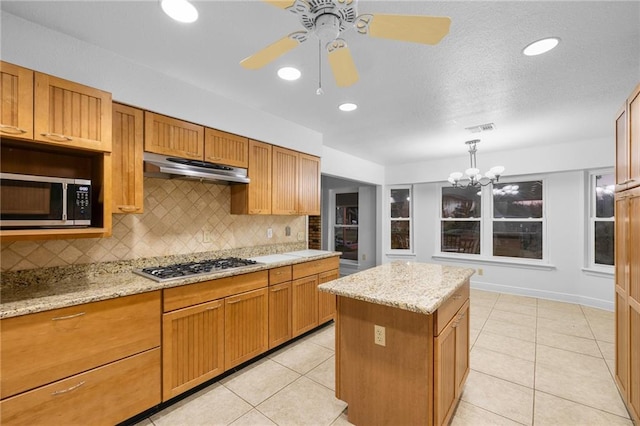 34222 Laurent Rd, Slidell, LA 70460 - kitchen with appliances with stainless steel finishes, under cabinet range hood, tasteful backsplash, a ceiling fan, and light tile patterned flooring