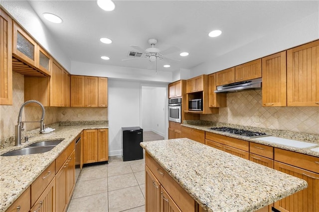 kitchen with sink, ceiling fan, light tile patterned floors, light stone counters, and stainless steel appliances