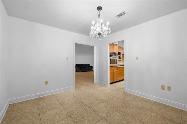 unfurnished dining area featuring light tile patterned floors and a chandelier