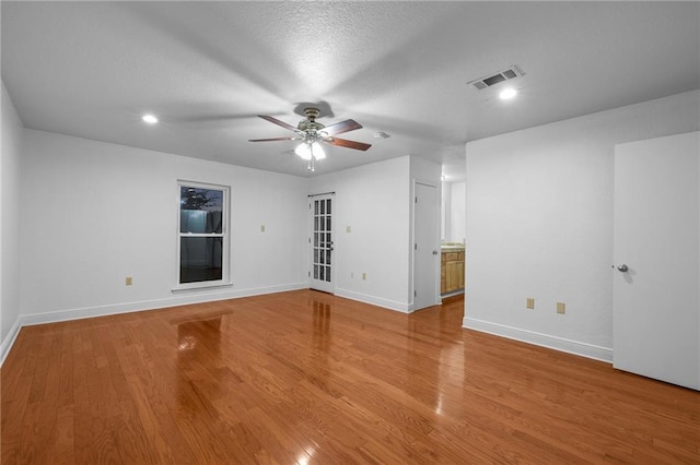 empty room featuring ceiling fan, a textured ceiling, and hardwood / wood-style flooring