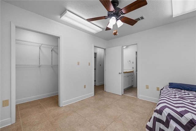 34222 Laurent Rd, Slidell, LA 70460 - bedroom with a closet, a textured ceiling, connected bathroom, ceiling fan, and light tile patterned flooring