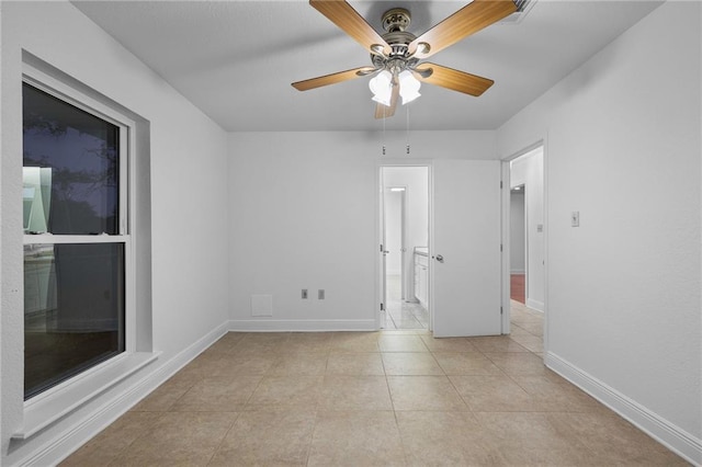 tiled spare room featuring ceiling fan