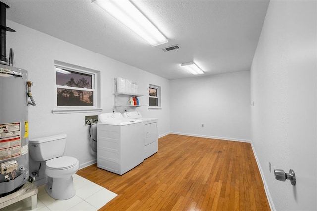 34222 Laurent Rd, Slidell, LA 70460 - bathroom with independent washer and dryer, water heater, vanity, wood finished floors, and a textured ceiling