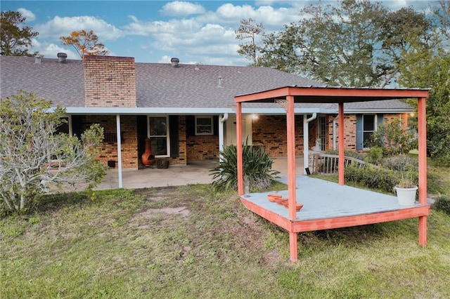 rear view of property with a yard and a patio