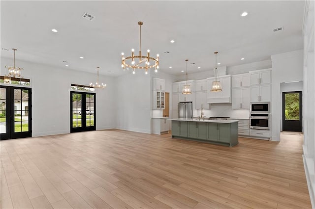 kitchen with a large island, french doors, stainless steel appliances, and plenty of natural light