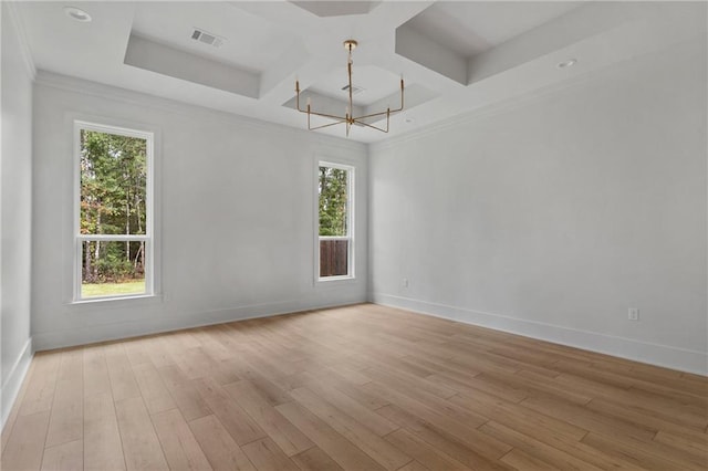 unfurnished room featuring light wood-type flooring, crown molding, a wealth of natural light, and a notable chandelier