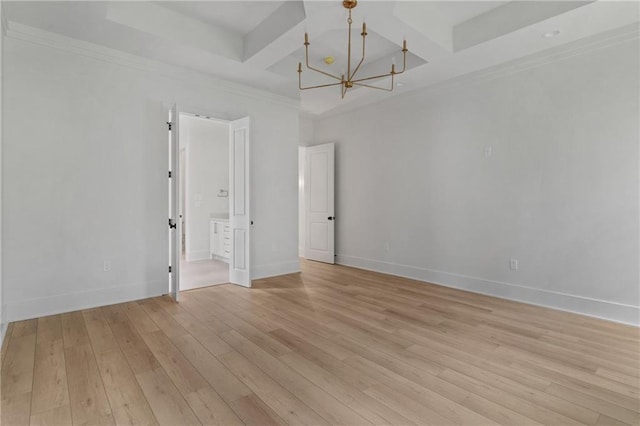 spare room with a chandelier, crown molding, and light hardwood / wood-style flooring