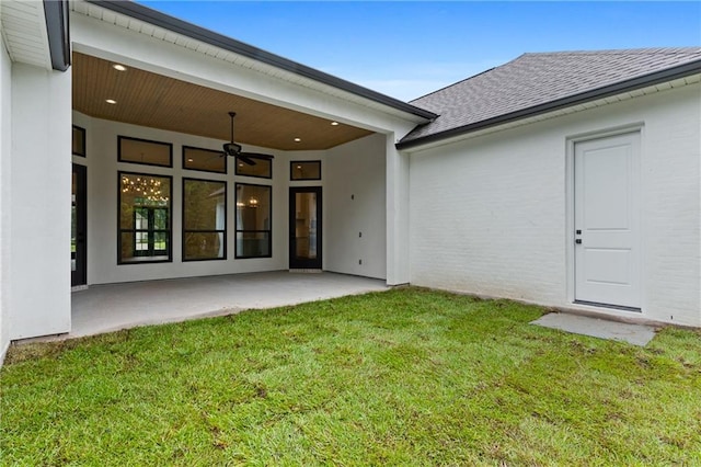 back of house featuring ceiling fan, a patio area, and a yard