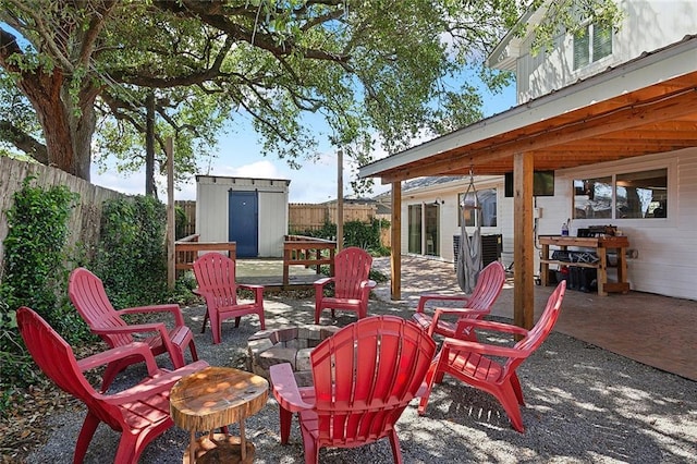 view of patio featuring a storage unit and an outdoor fire pit