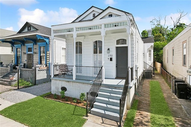 shotgun-style home with fence private yard, covered porch, and central air condition unit