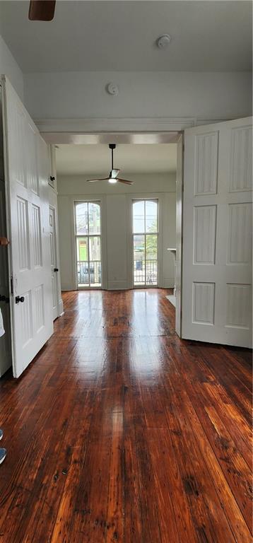 spare room featuring ceiling fan, a healthy amount of sunlight, and wood-type flooring