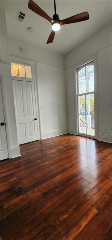 empty room with ceiling fan and dark hardwood / wood-style flooring