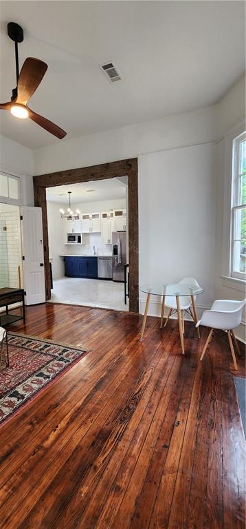 sitting room featuring ceiling fan with notable chandelier and wood-type flooring