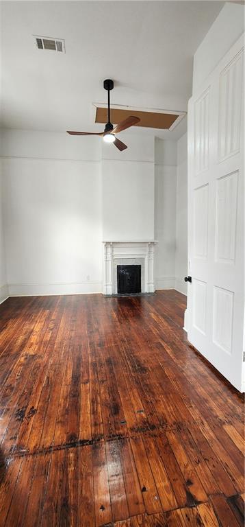 unfurnished living room with dark hardwood / wood-style floors and ceiling fan