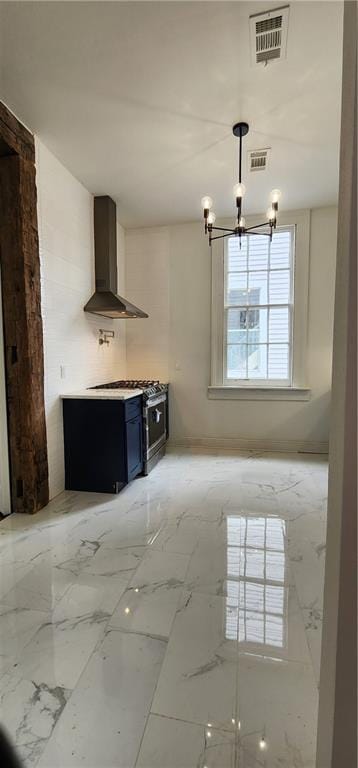 kitchen featuring a chandelier, pendant lighting, and wall chimney range hood