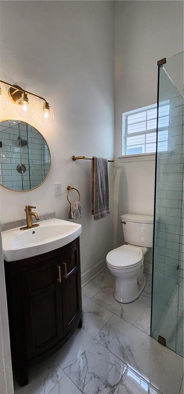 bathroom featuring vanity, toilet, and an enclosed shower