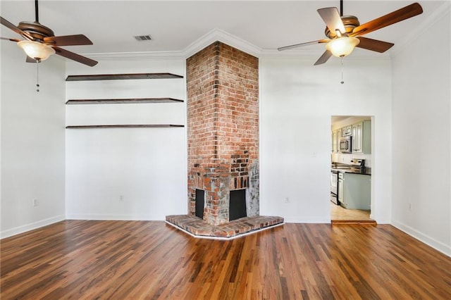 unfurnished living room featuring hardwood / wood-style floors, ceiling fan, crown molding, and a brick fireplace