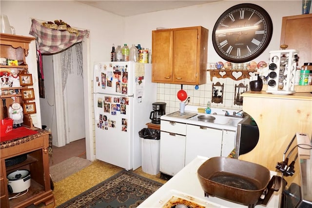 kitchen with white fridge, tasteful backsplash, and sink