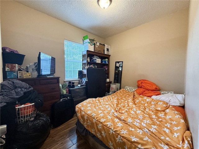 bedroom with hardwood / wood-style flooring and a textured ceiling