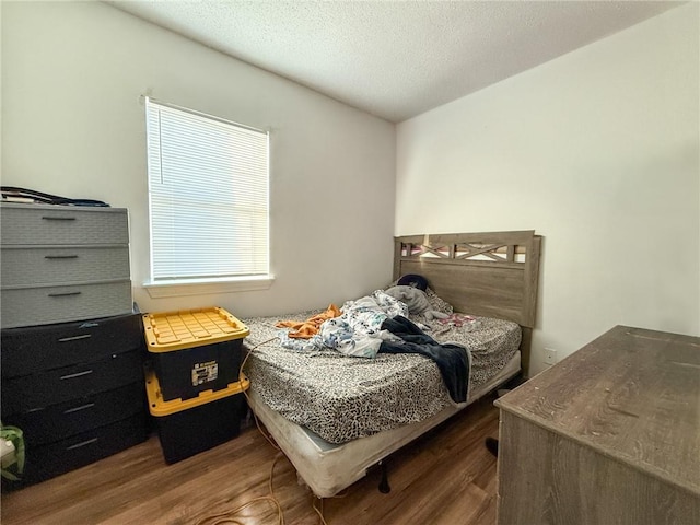 bedroom with a textured ceiling and dark wood-type flooring