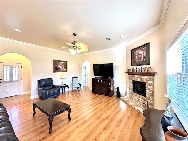 living area with a healthy amount of sunlight, arched walkways, and ornamental molding