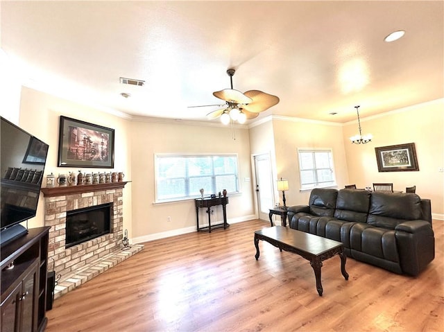 living room with visible vents, a brick fireplace, baseboards, ornamental molding, and light wood-style flooring