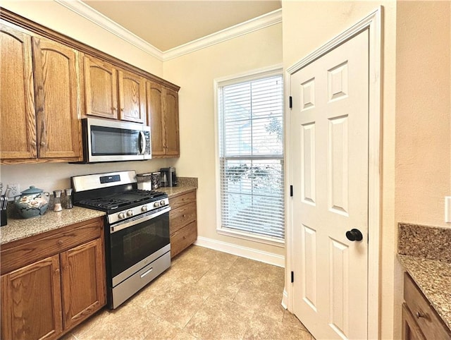 kitchen with baseboards, ornamental molding, light stone counters, appliances with stainless steel finishes, and brown cabinetry