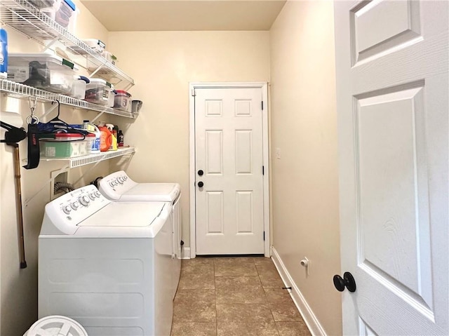 laundry room featuring light tile patterned floors, baseboards, laundry area, and washer and clothes dryer