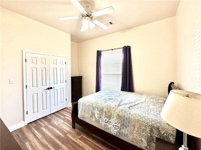 bedroom featuring visible vents, a ceiling fan, baseboards, and wood finished floors